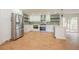 Bright kitchen featuring stainless steel appliances, white cabinetry, and a stylish green backsplash at 11383 W 28Th Ave, Lakewood, CO 80215