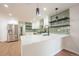 Open kitchen with stainless steel appliances, a large island, and stylish green backsplash at 11383 W 28Th Ave, Lakewood, CO 80215