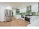 Well-lit kitchen with white cabinets, stainless steel appliances, and a vibrant green backsplash at 11383 W 28Th Ave, Lakewood, CO 80215