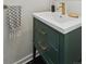Stylish bathroom vanity with green cabinets, gold hardware, and a modern faucet at 4978 Camel Heights Rd, Evergreen, CO 80439