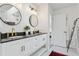 Bright bathroom featuring double vanity with sleek black countertop and round mirrors at 4978 Camel Heights Rd, Evergreen, CO 80439