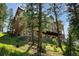 Exterior view of a luxury home with an outdoor patio and wooden balcony at 4978 Camel Heights Rd, Evergreen, CO 80439