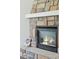 Close up of a cozy fireplace with stone surround, mantle, and gas logs at 4978 Camel Heights Rd, Evergreen, CO 80439