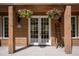 Inviting entryway with double doors, hanging flower baskets, and wood accents, creating a warm and charming ambiance at 4978 Camel Heights Rd, Evergreen, CO 80439