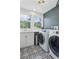 Well-lit laundry room with modern washer and dryer and patterned tile floor at 4978 Camel Heights Rd, Evergreen, CO 80439