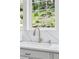 Modern kitchen sink with stainless faucet overlooking lush landscaping at 4978 Camel Heights Rd, Evergreen, CO 80439