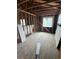 Bright, unfinished room with exposed wood framing, showcasing the hardwood floors and potential for customization at 1105 S Raleigh St, Denver, CO 80219