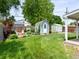 Large grassy backyard with a charming blue shed, a fire pit, and a wooden fence at 6223 Gray St, Arvada, CO 80003