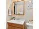Well-lit bathroom vanity with wooden mirror, complemented by fresh floral decor and modern fixtures at 6223 Gray St, Arvada, CO 80003