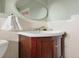 Bathroom features white tile, dark wood vanity with a round mirror and silver hardware at 6223 Gray St, Arvada, CO 80003