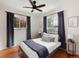 Bedroom with hardwood floors, ceiling fan, and natural light from dual windows with dark curtains at 6223 Gray St, Arvada, CO 80003