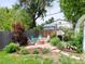 Backyard stone fire pit with four chairs, lush landscaping, and a privacy fence at 6223 Gray St, Arvada, CO 80003