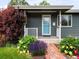 Welcoming front porch with a vibrant garden and brick path leading to the entrance at 6223 Gray St, Arvada, CO 80003