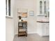 Bright kitchen features a rolling bar cart, white cabinets, and butcher block countertops at 6223 Gray St, Arvada, CO 80003