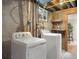 Functional laundry area featuring modern washer and dryer units with exposed concrete and wood beam ceilings at 6223 Gray St, Arvada, CO 80003