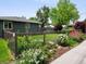 Well-manicured lawn featuring flowerbeds, and a privacy fence bordering the property at 6223 Gray St, Arvada, CO 80003