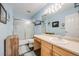 A well-lit bathroom featuring a tub shower, vanity, and light-blue walls at 13275 Holly St # E, Thornton, CO 80241