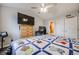 Comfortable bedroom with ceiling fan, TV, closet, and attached bathroom at 13275 Holly St # E, Thornton, CO 80241