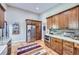 Bright kitchen boasts stainless steel appliances, wood cabinets, brick backsplash, granite countertops, and wood floors at 424 Peery Pkwy, Golden, CO 80403