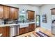 Kitchen featuring wood cabinets, granite countertops, brick backsplash, farmhouse sink, and stainless steel appliances at 424 Peery Pkwy, Golden, CO 80403