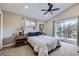 Bedroom features a fan, neutral carpet, large window with sliding glass door, and ensuite bath at 424 Peery Pkwy, Golden, CO 80403