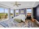 A well-lit main bedroom with hardwood floors, bright windows with views, and an elegant rug at 19887 Kershaw Ct, Monument, CO 80132