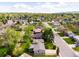 An aerial view of a neighborhood showcases lush greenery, houses, and tree-lined streets against a backdrop of rolling hills at 3322 Simms St, Wheat Ridge, CO 80033