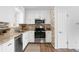 Updated kitchen with stainless steel appliances, decorative tile backsplash, and modern cabinetry at 3322 Simms St, Wheat Ridge, CO 80033