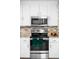 Close-up of stainless steel oven with backsplash and stainless steel microwave above it at 3322 Simms St, Wheat Ridge, CO 80033
