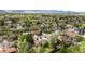 A cozy neighborhood featuring mature trees, well-maintained lawns, and the majestic mountain range in the background at 3322 Simms St, Wheat Ridge, CO 80033