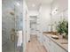 Luxurious bathroom showcasing a glass shower, double vanity, and access to a walk-in closet at 3909 Piney Grove St, Evergreen, CO 80439