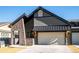 Striking home exterior featuring stone accents, a dark roof, and a two-car garage at 3909 Piney Grove St, Evergreen, CO 80439