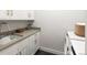 Laundry room with white cabinets, counter space, sink, and modern washer/dryer at 3909 Piney Grove St, Evergreen, CO 80439