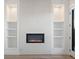 Living room with modern fireplace, built-in shelves, and bright recessed lighting at 3909 Piney Grove St, Evergreen, CO 80439