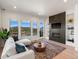 Bright living room boasts modern fireplace, built-in shelves, and mountain views from large windows at 3909 Piney Grove St, Evergreen, CO 80439