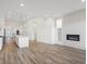 Open-concept living space featuring wood floors, fireplace, and eat-in kitchen with a large island at 3909 Piney Grove St, Evergreen, CO 80439