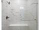 Modern shower featuring marble-style tiling, a built-in seat, and sleek fixtures at 3909 Piney Grove St, Evergreen, CO 80439