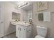 Bathroom with a large mirror, vanity, lighting fixture, and decorative greenery art at 7440 S Blackhawk St # 2-108, Englewood, CO 80112