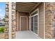 Stylish condo with a covered front porch, stone pillars, brown siding, and a brown front door at 7440 S Blackhawk St # 2-108, Englewood, CO 80112