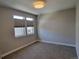 Bright bedroom with neutral walls and carpet, featuring two large windows with blinds at 5021 S Prince Pl, Littleton, CO 80123