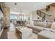 Spacious open-concept living area with modern furnishings, staircase, and adjacent dining and kitchen areas at 5021 S Prince Pl, Littleton, CO 80123