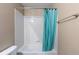 Tiled shower/tub combo features a stylish, bright blue shower curtain at 7774 E 137Th Ave, Thornton, CO 80602