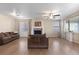 Bright living room boasts a cozy fireplace, ceiling fan, and natural light from large windows at 7774 E 137Th Ave, Thornton, CO 80602