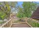 Balcony with a wooden floor and railing, offering a view of the street and mature trees at 1356 N Marion St, Denver, CO 80218