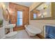 Bright bathroom with clawfoot tub, exposed brick wall, pedestal sink, and decorative mirror for vintage charm at 1356 N Marion St, Denver, CO 80218