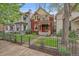 Charming two-story home boasts a well-manicured front yard and inviting curb appeal with black iron fence at 1356 N Marion St, Denver, CO 80218