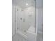 White tiled shower with glass door and bench, features mosaic tile floor, niche, and chrome showerhead at 1356 N Marion St, Denver, CO 80218