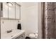 Well-lit bathroom with gray vanity, cabinets, and hardware, paired with a clean white sink and toilet at 12935 W 64Th Dr # D, Arvada, CO 80004
