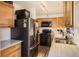 Well-lit kitchen featuring oak cabinets, a black oven, stainless steel refrigerator, and a tiled backsplash at 12935 W 64Th Dr # D, Arvada, CO 80004