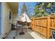 Private patio area with outdoor seating under an umbrella, enclosed by a wooden fence and lush greenery at 12935 W 64Th Dr # D, Arvada, CO 80004